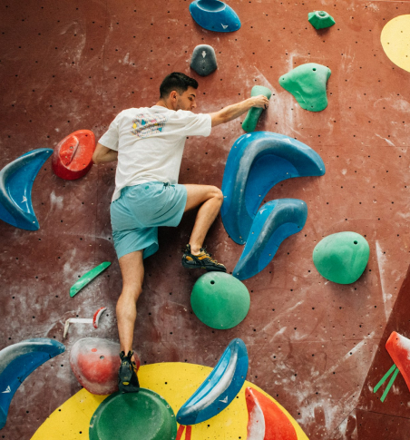 A man climbing a boulder indoors